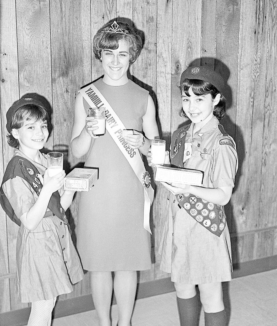 Yamhill Dairy Princess and 2 young girls holding glasses of milk.