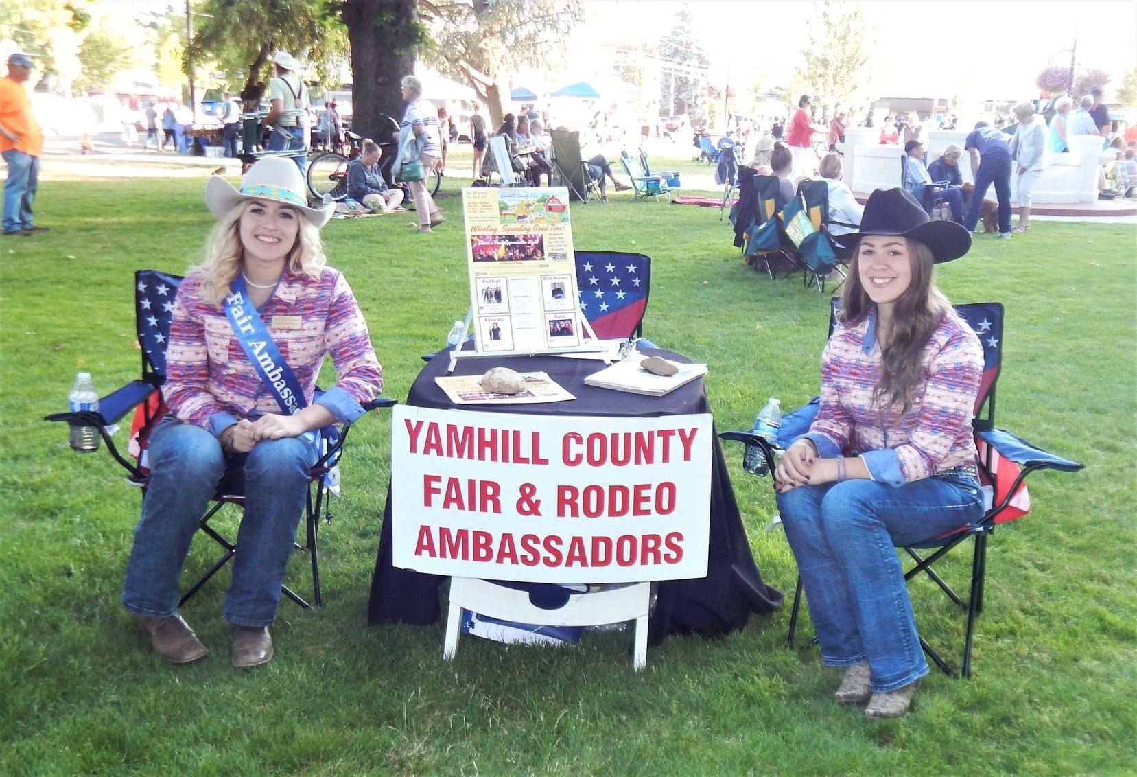 Young ladies sitting at Yamhill County Fair and Rodeo Ambassadors table